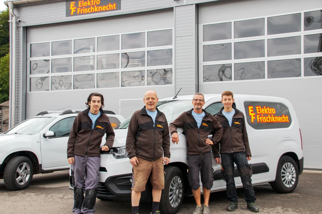 Das Team von Elektro Frischknecht posiert vor den Firmenfahrzeugen